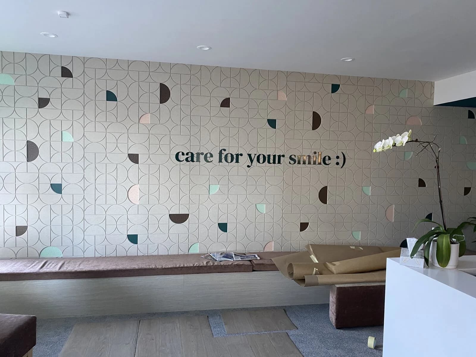 Custom patterned acoustic feature wall with pastel and charcoal circles in the Emmaus Dental reception