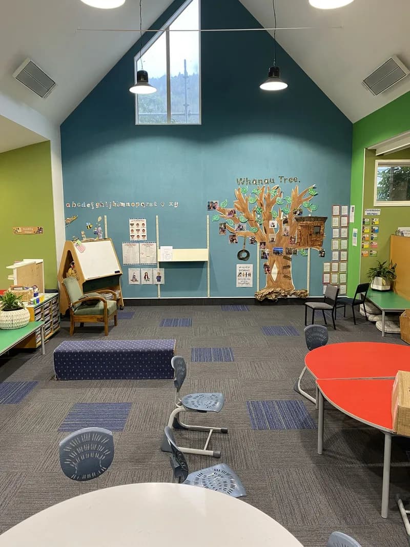 Library with green and blue acoustic walls, colourful kids tables and patterned carpet at Hampden Street School