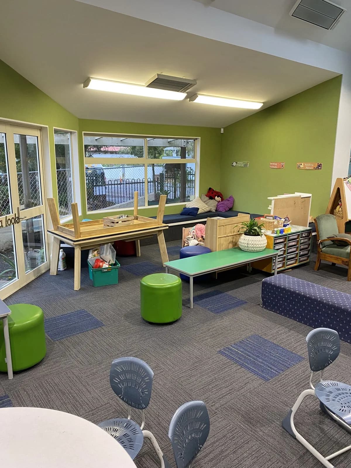 Green-walled learning space with kids furniture and patterned carpet at Hampden Street School