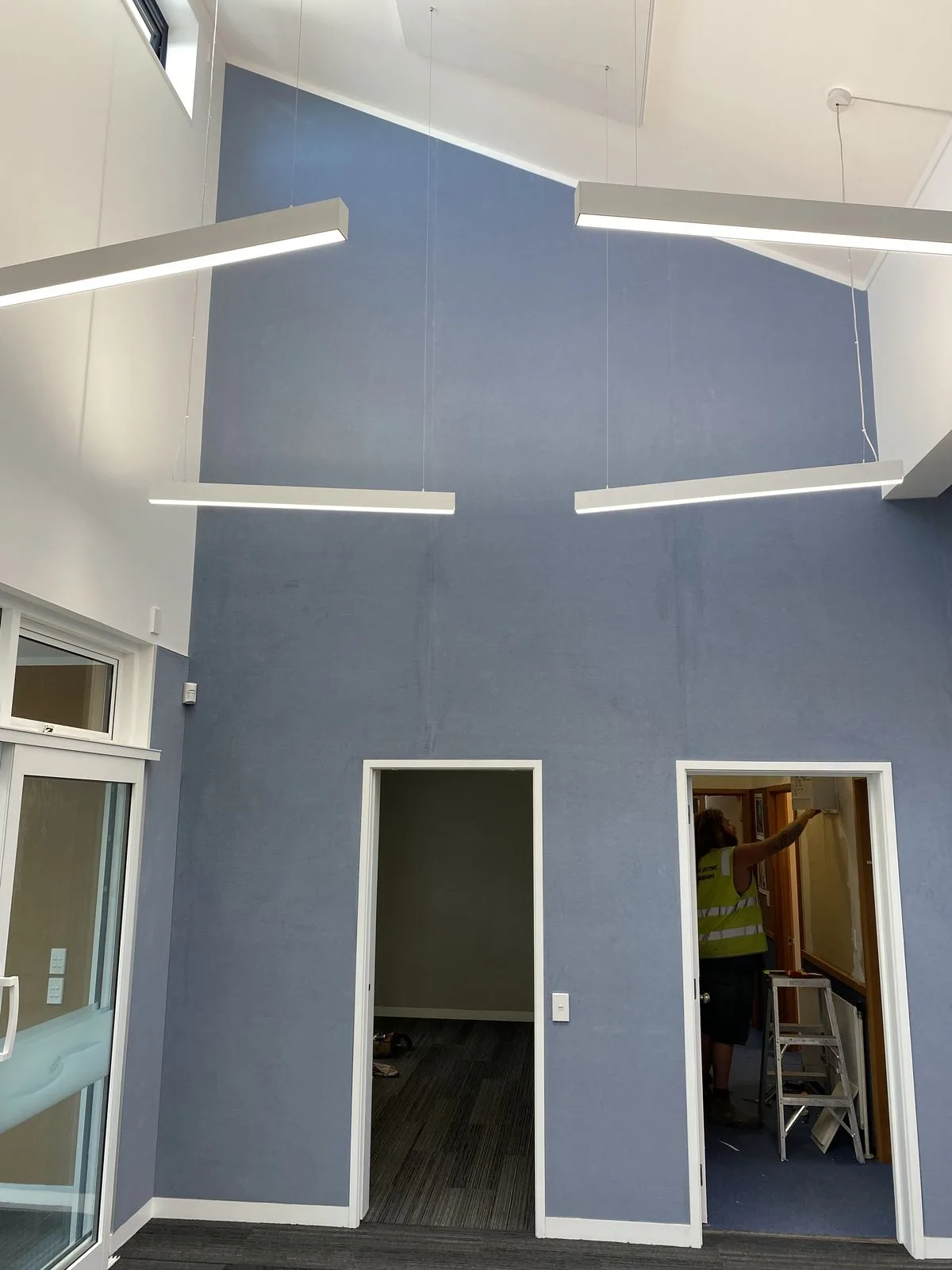 Blue painted acoustic wall overlay with white pendant lights at Hampden Street School
