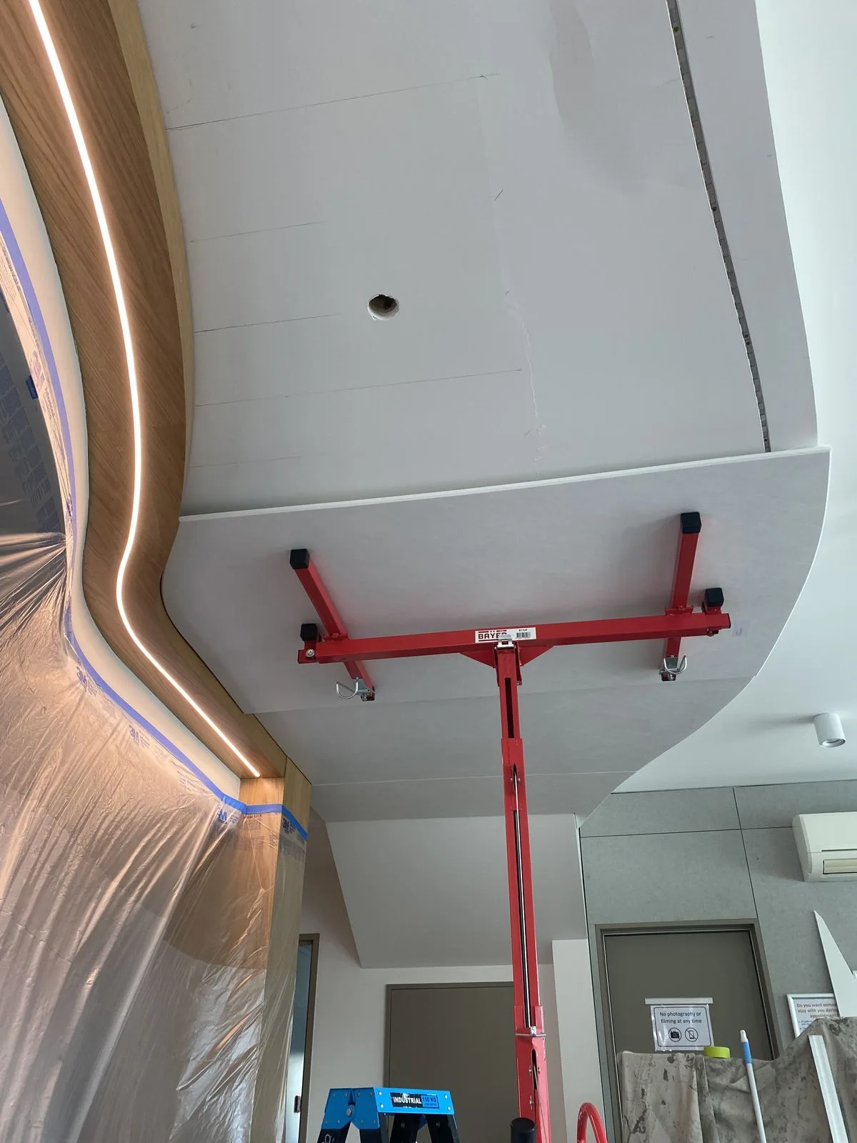 Curved wall install held by red acrow props during construction at Riccarton Doctors