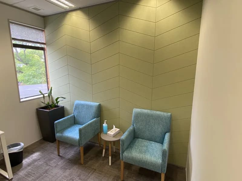 Greenish-grey Groove panels laid in a chevron pattern in the St George waiting room with teal armchairs