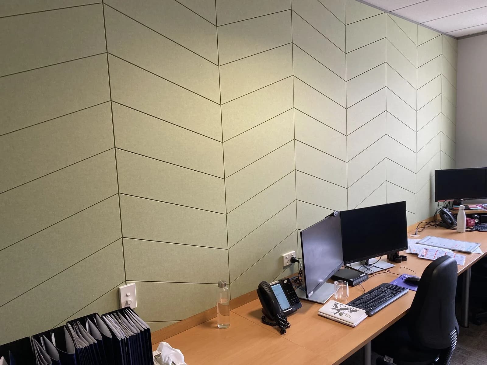 Chevron-laid greenish Groove panels behind an office desk with monitors at St George Hospital